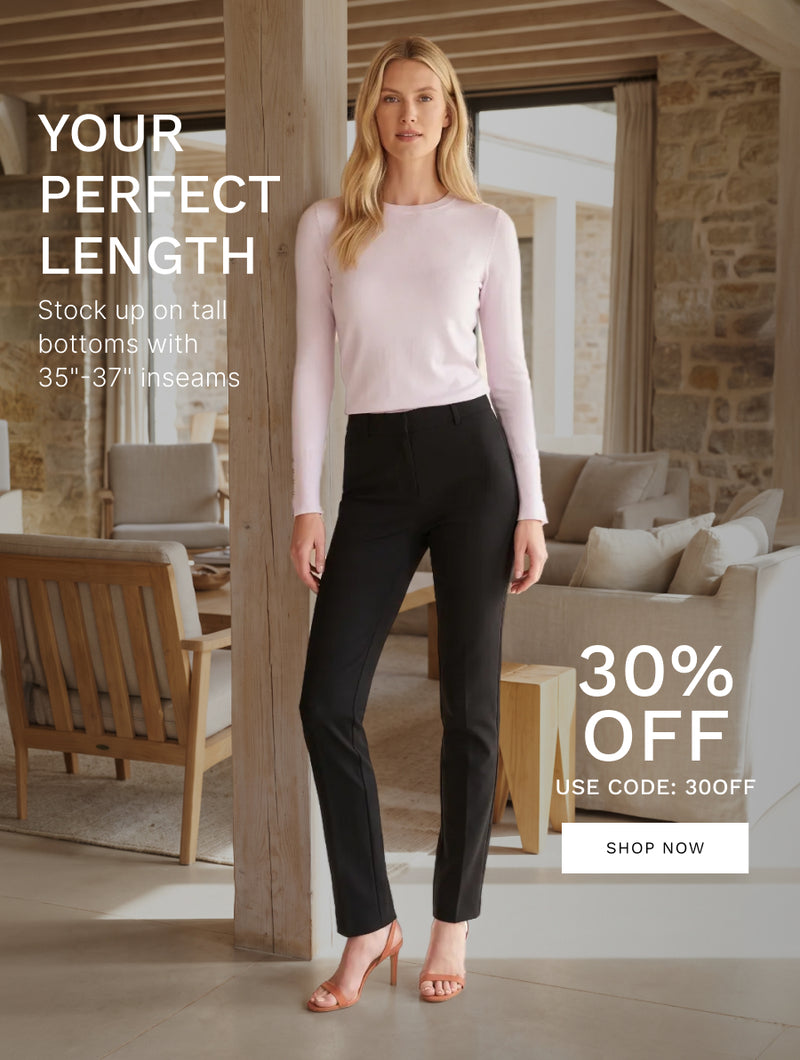 Woman wearing a pink long-sleeve top and black tall-length pants in a bright, modern home, showcasing 35–37 inch inseams.