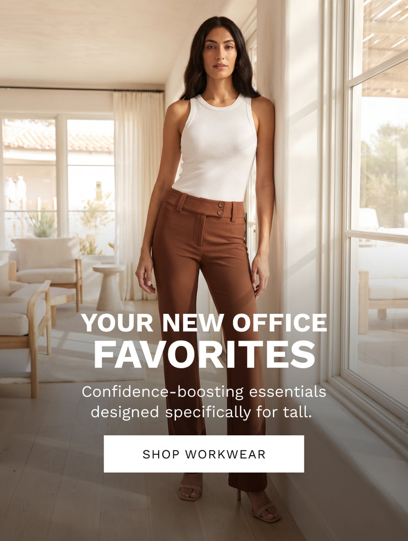 A woman stands indoors wearing a sleeveless white top and brown tailored pants, with large windows and furniture visible in the background. Large overlaid text reads 'YOUR NEW OFFICE FAVORITES' and 'SHOP WORKWEAR'.